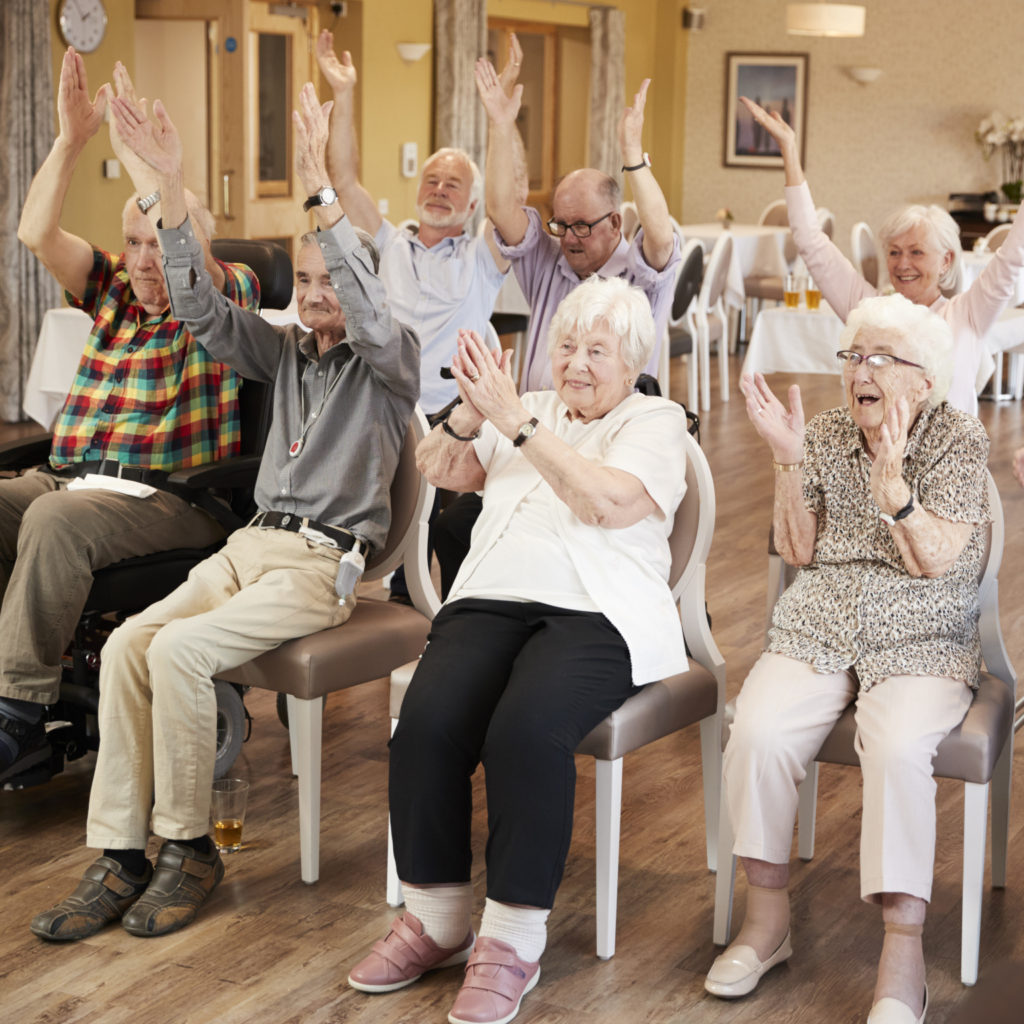 Group Of Seniors Enjoying Fitness Class In Retirement Home